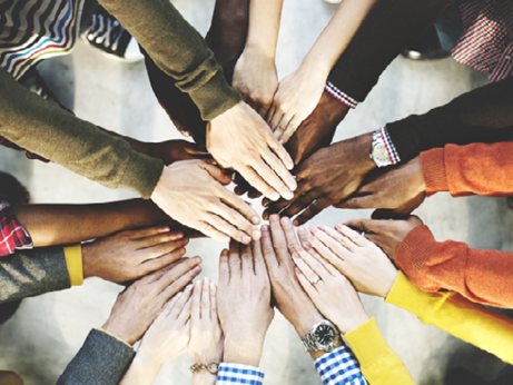 Group of people holding their hands in a circle