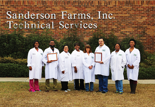 Lab workers in front of tech building