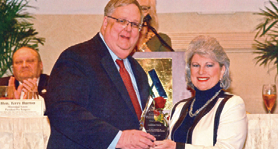 Man and woman holding plaque