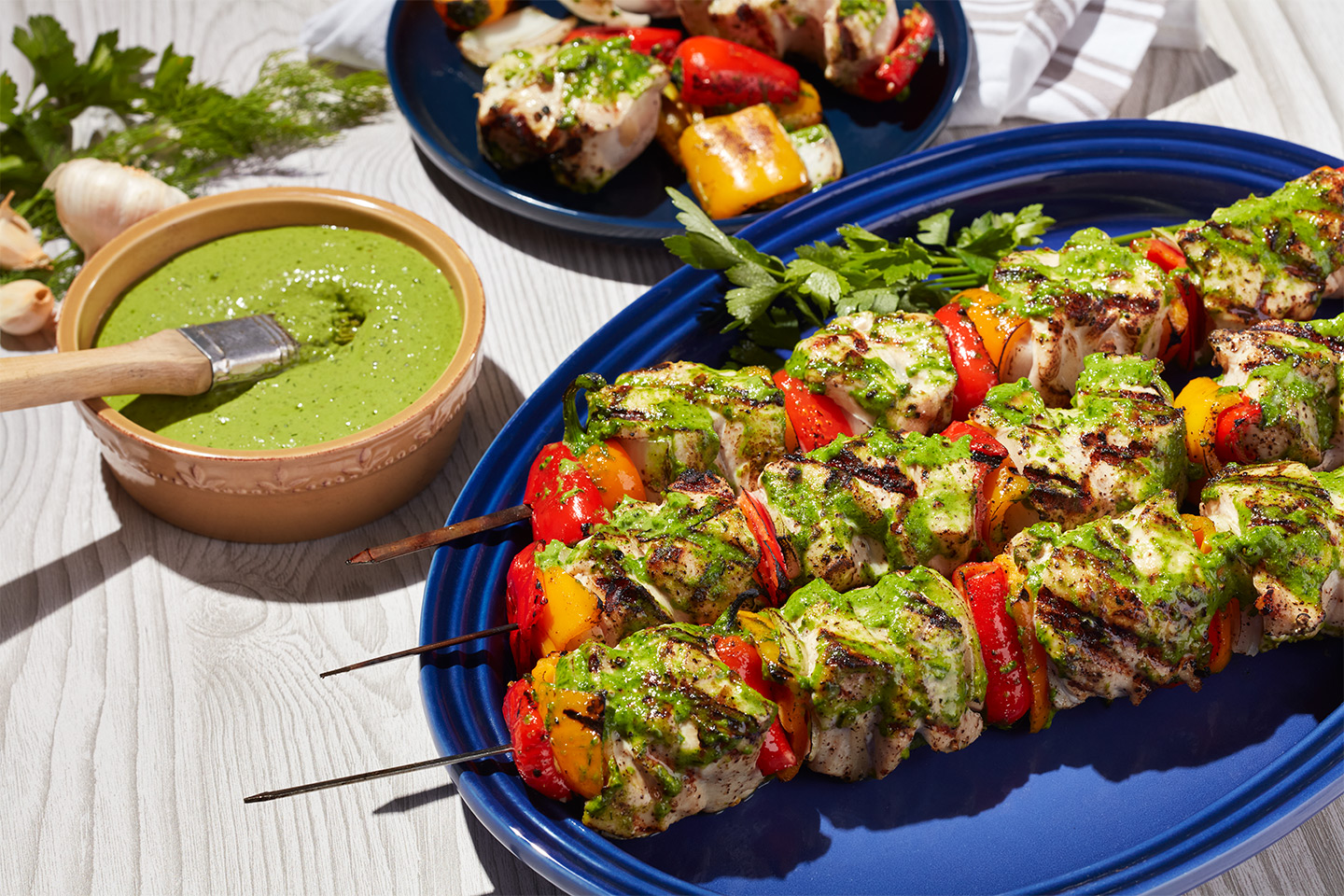 Pollo a la parrilla con hierbas en brochetas, con glaseado de ajo verde